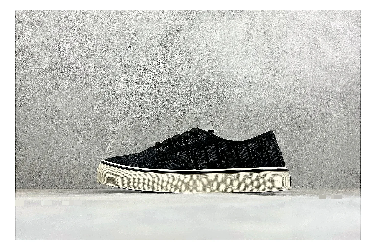 Dior Act Slide Black Low-Top budget find photo showing black monogram-style upper, low slip-on shape, chunky dark sole, and luxury casual profile